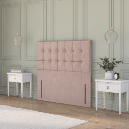  Beige plush velvet strutted headboard with a chesterfield design in a rustic cottage bedroom between two bedside tables.